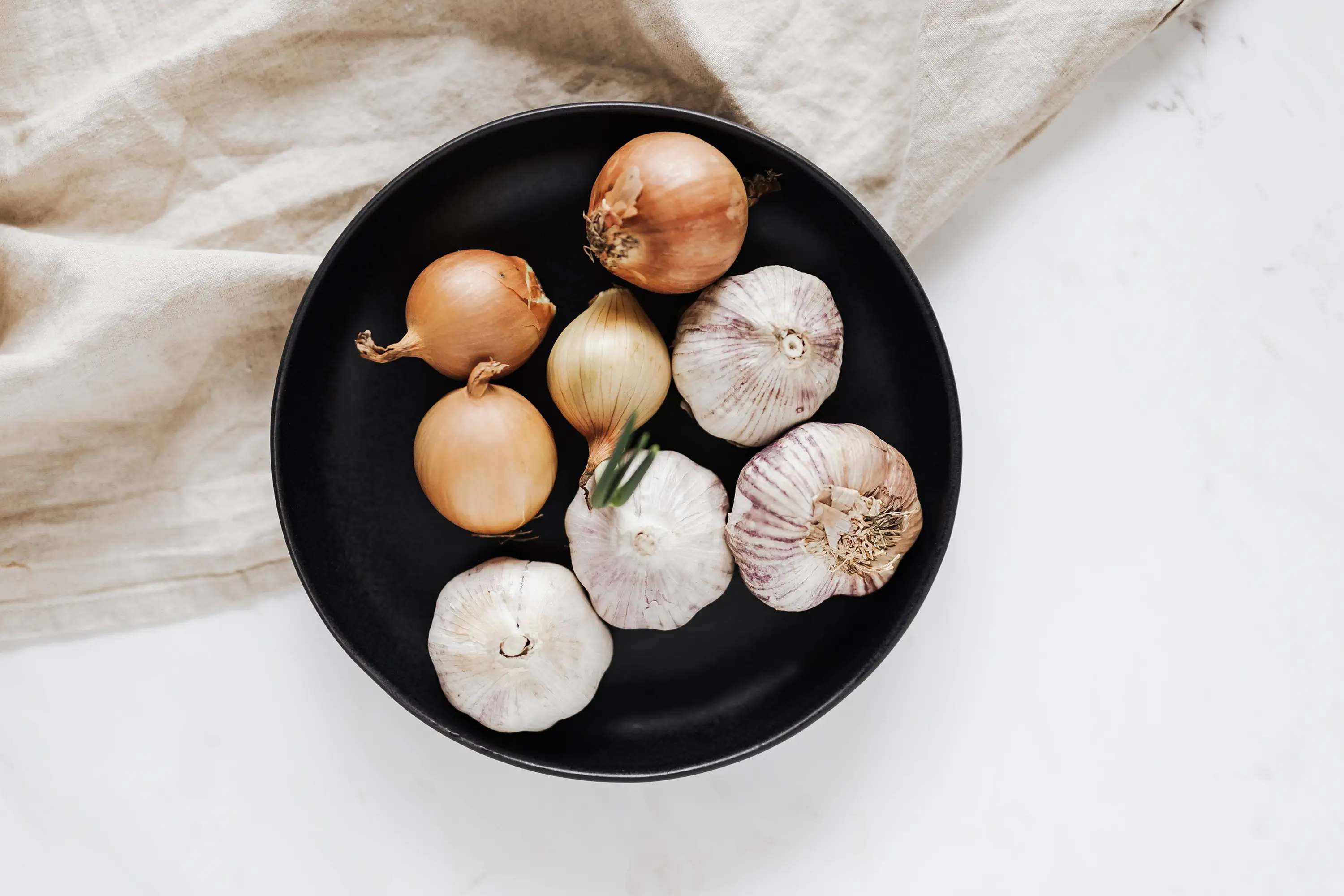 a black plate of garlic and onions